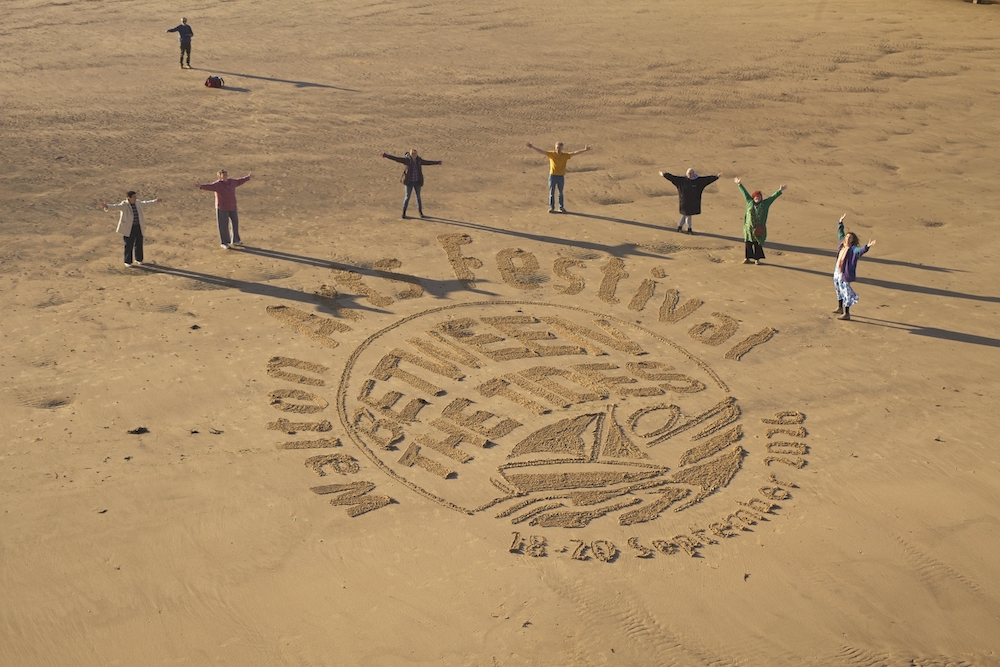 Grote strandtekening voor Walton Arts Festival, met mensen rond het kunstwerk